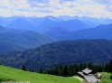 Blick von einem Berg über bewaldete Berge ins Karwendelgebirge